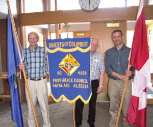 Brother Knight Dennis Hoynick with Province of Alberta, Grand Knight Doyle Badry with Knights of Columbus Pennant, and Brother Knight Greg Hamm with the Canadian Flag were part of the presentation of the colours during a program celebrating the 60th anniversary of the Daysland Knights of Columbus Providence Council, #4008.