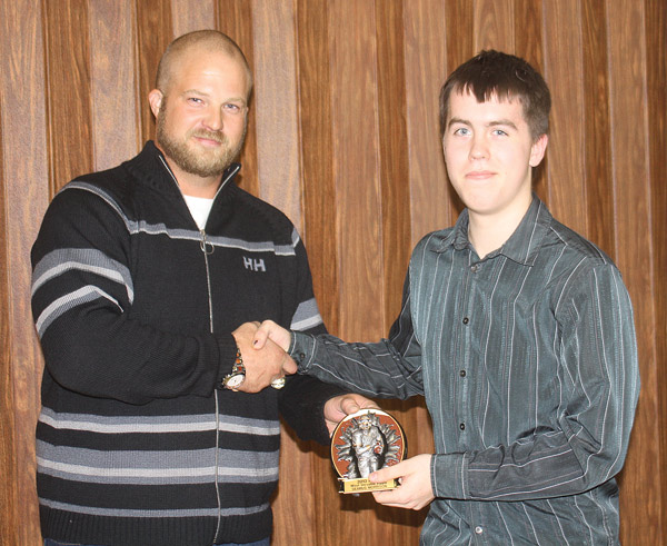 Seamus Morrison accepts the Most Versatile Player award from coach Kevin Lefsrud