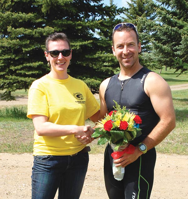 Derek Lewis was the first to cross the finish line Saturday, and received a bouquet, shown here with Sedgewick CAO Amanda Davis