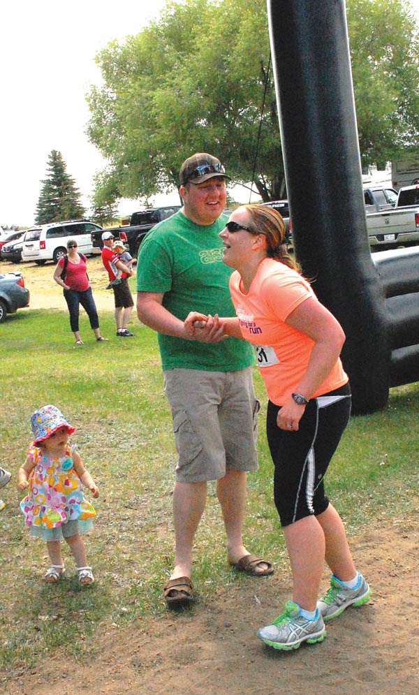 Heather Snethun greeted by family as she crosses the finish.