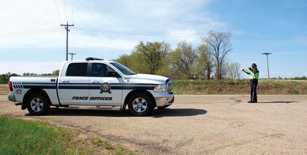 Flagstaff County Peace Office Jim Wells directs Westbound traffic on Highway 13